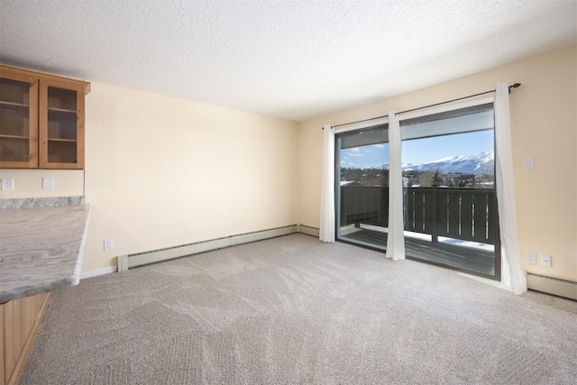 unfurnished room featuring light carpet, baseboard heating, and a textured ceiling