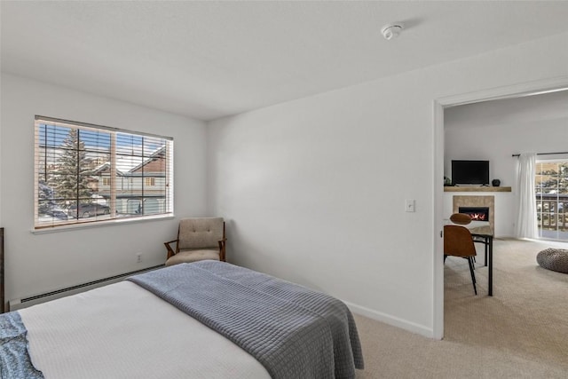 carpeted bedroom featuring baseboard heating and a tile fireplace