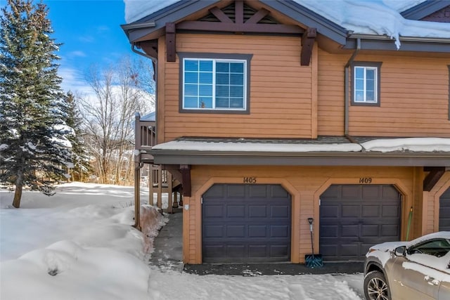 view of snowy exterior with a garage