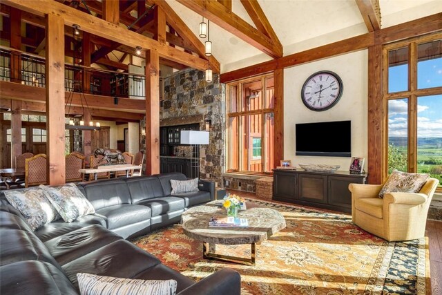 living room with beamed ceiling, high vaulted ceiling, a chandelier, and wood-type flooring