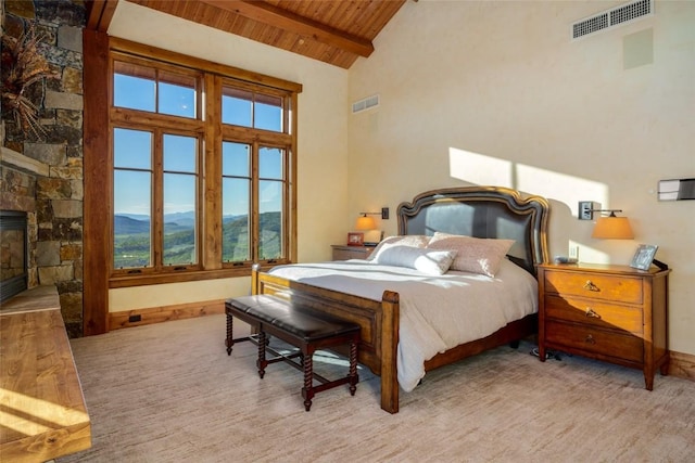 bedroom featuring a mountain view, wooden ceiling, high vaulted ceiling, a fireplace, and beam ceiling