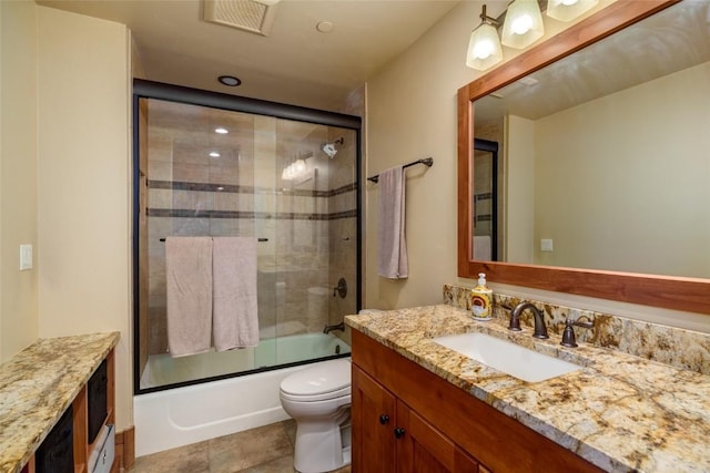 full bathroom featuring tile patterned flooring, vanity, toilet, and bath / shower combo with glass door