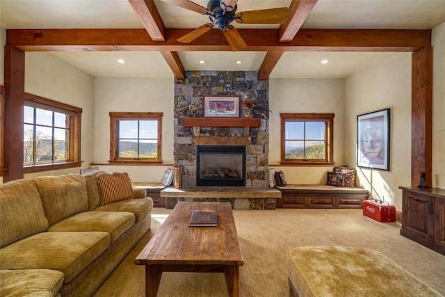 carpeted living room featuring a fireplace, beam ceiling, and a healthy amount of sunlight