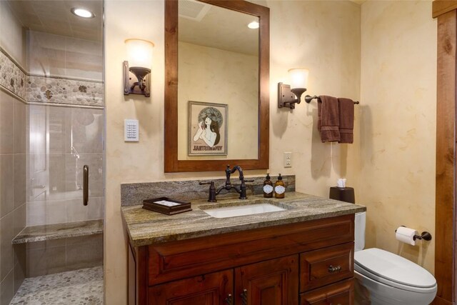 bathroom featuring vanity, an enclosed shower, and toilet