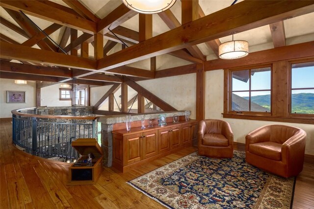 living area with lofted ceiling with beams and light wood-type flooring