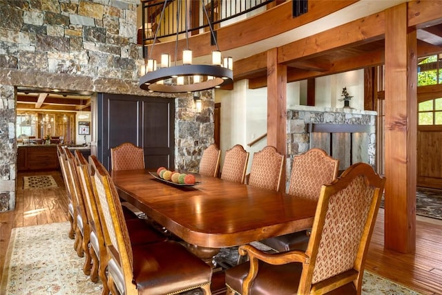 dining room with hardwood / wood-style flooring, a fireplace, and an inviting chandelier