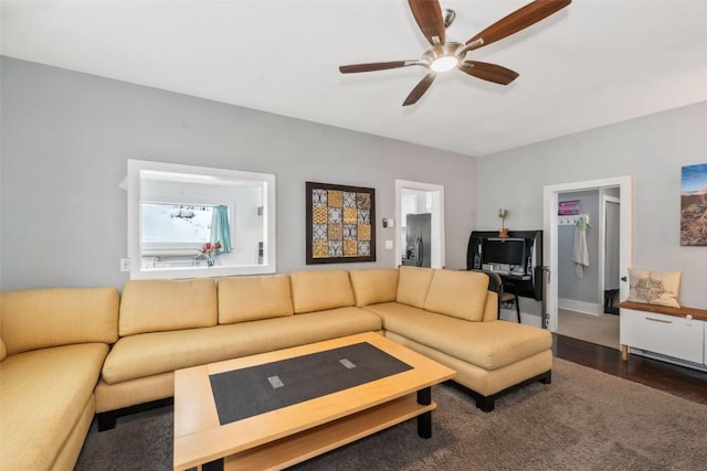 living room featuring dark wood-type flooring and ceiling fan