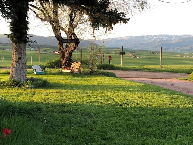 view of property's community featuring a mountain view, a rural view, and a lawn