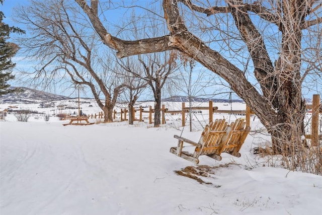 yard covered in snow featuring a mountain view