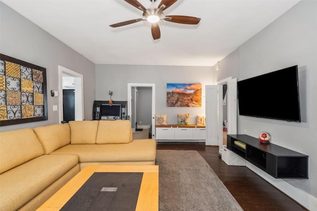 living room featuring ceiling fan and dark wood-type flooring