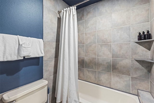 bathroom featuring shower / tub combo and toilet