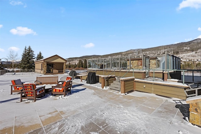 snow covered patio with a mountain view