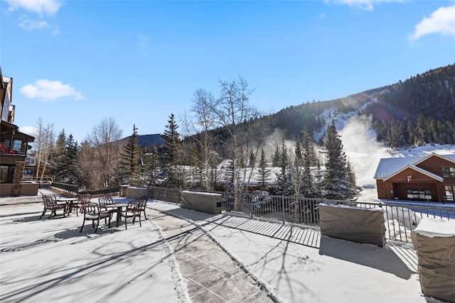 snow covered patio with a mountain view