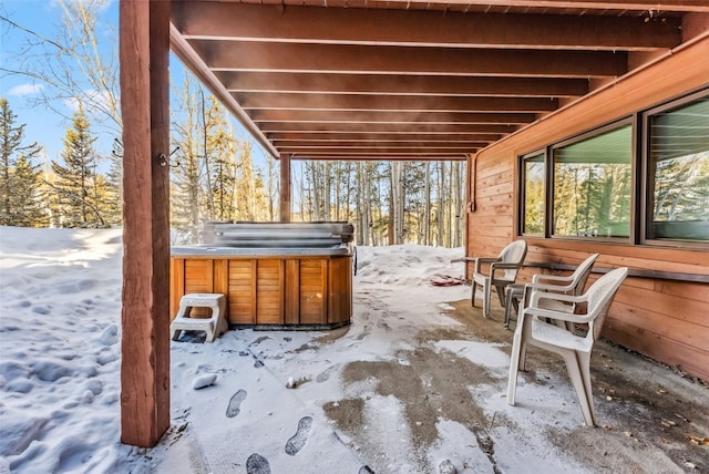 snow covered patio featuring a hot tub