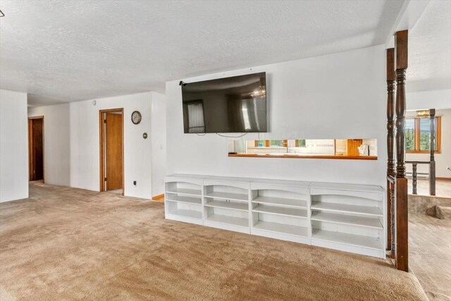 unfurnished living room featuring a textured ceiling and carpet floors