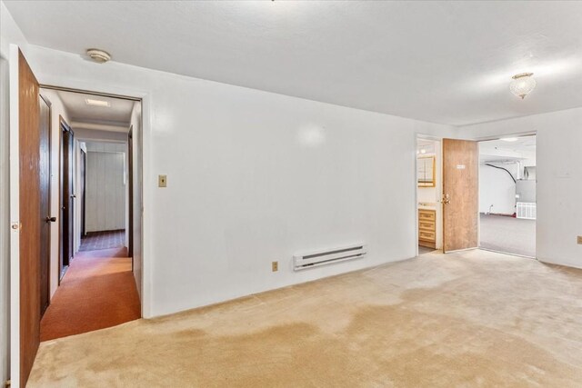 carpeted empty room featuring a baseboard radiator