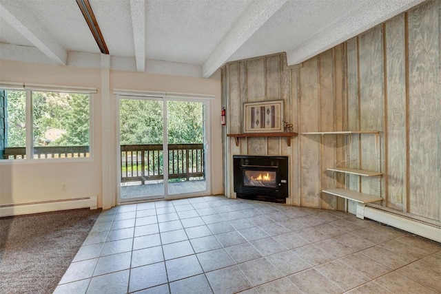 unfurnished living room featuring a textured ceiling, baseboard heating, a tile fireplace, beamed ceiling, and wood walls