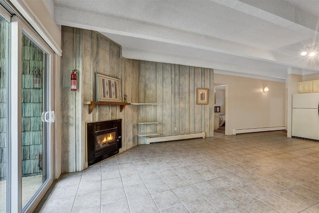 unfurnished living room with beam ceiling, wooden walls, a baseboard radiator, and a textured ceiling