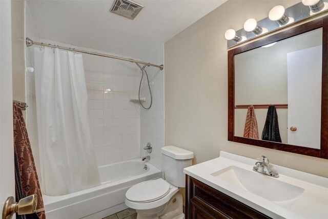 full bathroom with tile patterned floors, vanity, toilet, and shower / bath combo with shower curtain