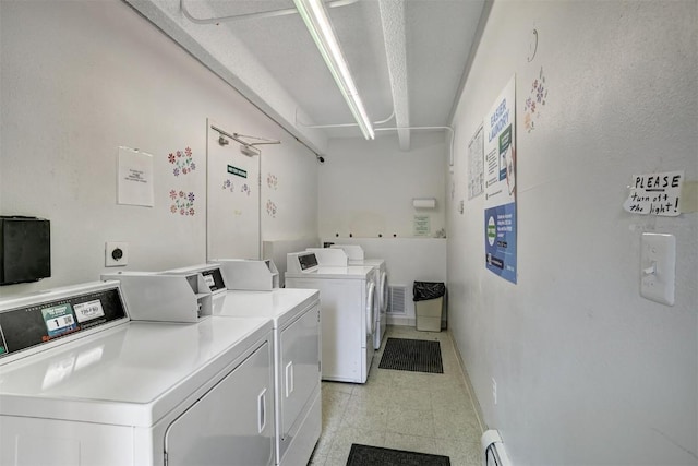 washroom featuring baseboard heating and washer and clothes dryer