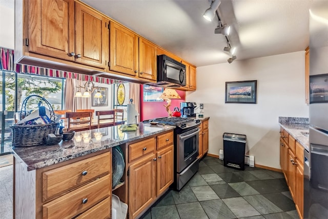 kitchen featuring light stone countertops, gas range, and track lighting