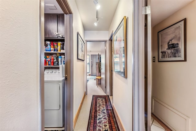 hallway with washer / clothes dryer and track lighting