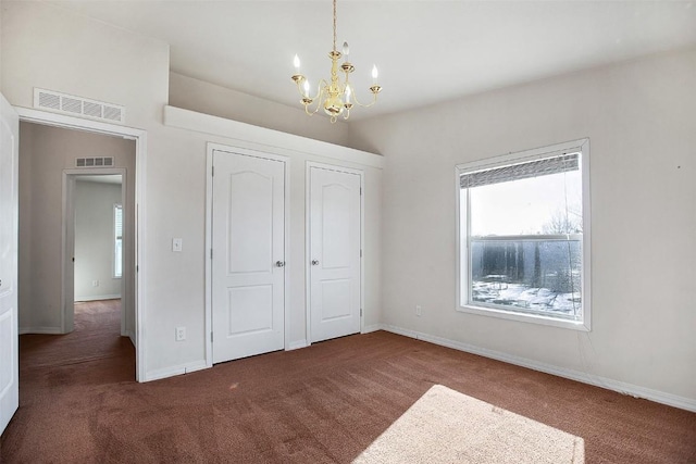 unfurnished bedroom with visible vents, carpet floors, a notable chandelier, and baseboards