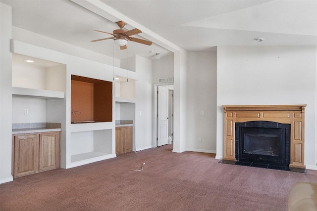 unfurnished living room with ceiling fan, baseboards, carpet, vaulted ceiling, and a tile fireplace