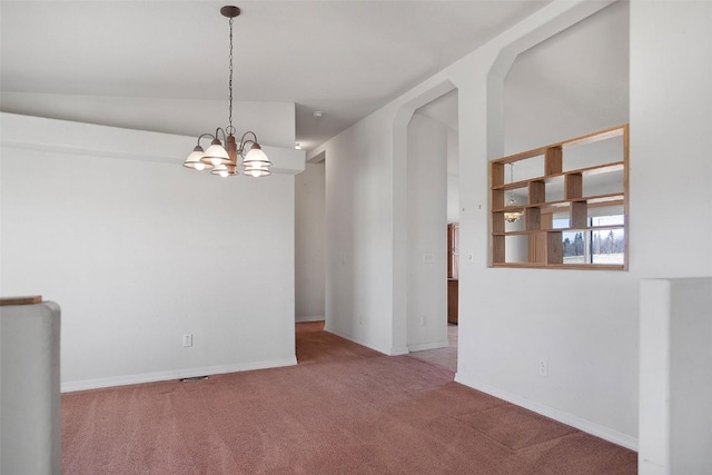 carpeted empty room featuring arched walkways, an inviting chandelier, and baseboards