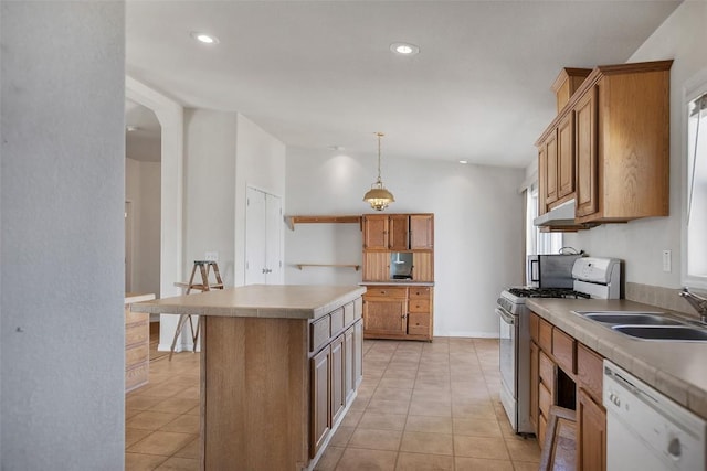 kitchen featuring a sink, a center island, light tile patterned flooring, gas range, and dishwasher