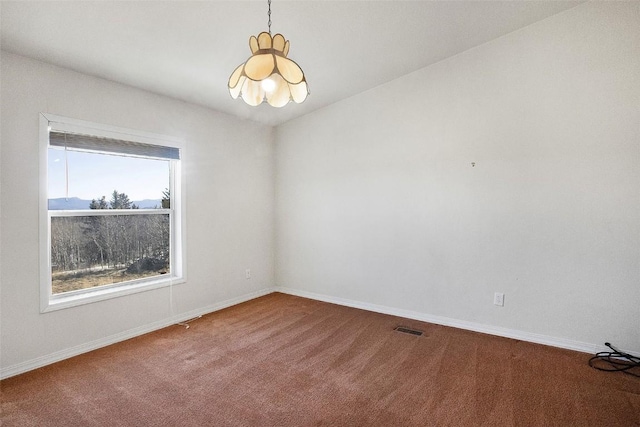 carpeted empty room featuring visible vents and baseboards