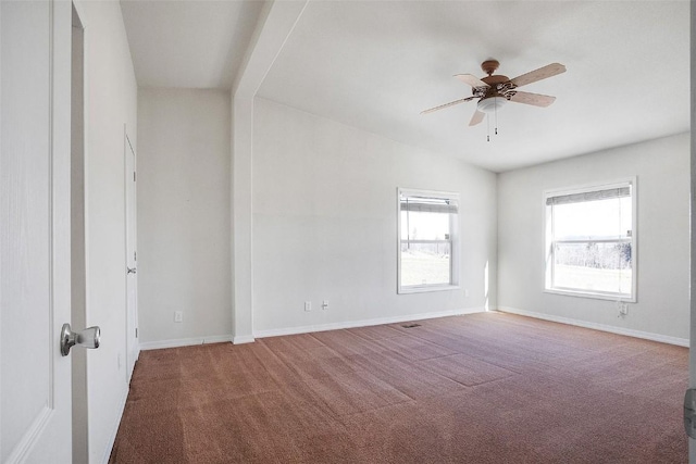 carpeted empty room with vaulted ceiling, visible vents, baseboards, and ceiling fan