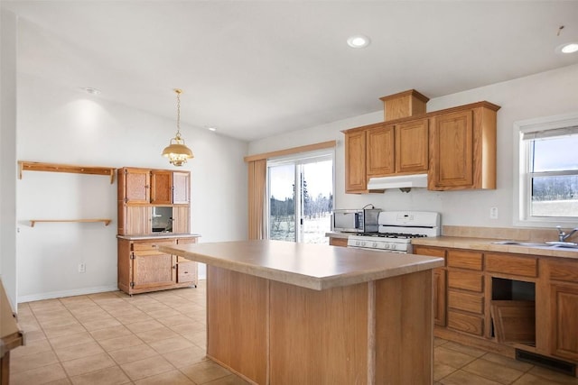 kitchen featuring under cabinet range hood, plenty of natural light, white gas stove, and a sink