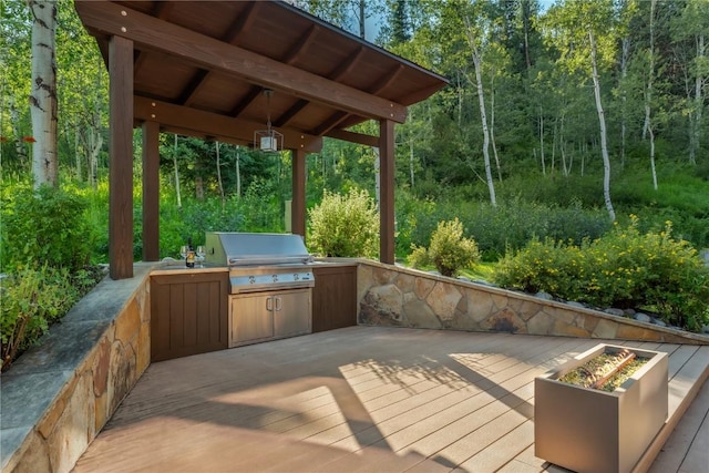 wooden terrace featuring an outdoor kitchen and grilling area