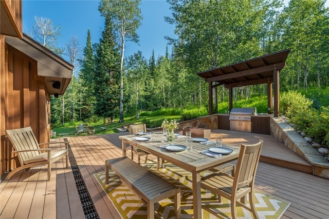 wooden deck with area for grilling and exterior kitchen