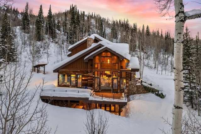 snow covered rear of property with a porch