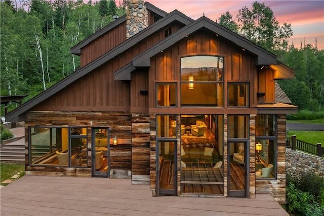 back house at dusk with a wooden deck