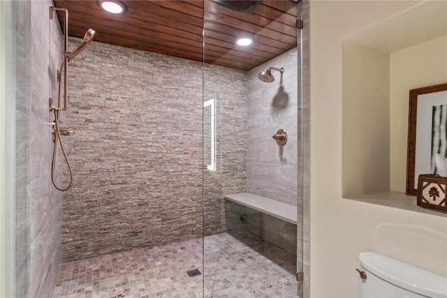 bathroom featuring toilet and a tile shower