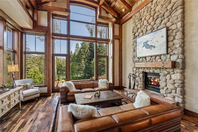 interior space featuring wooden ceiling, a healthy amount of sunlight, a fireplace, and vaulted ceiling with beams