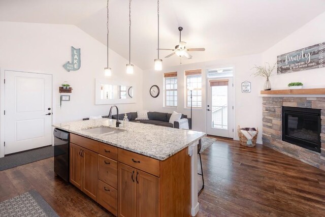 kitchen featuring vaulted ceiling, ceiling fan, a kitchen island with sink, sink, and dishwasher