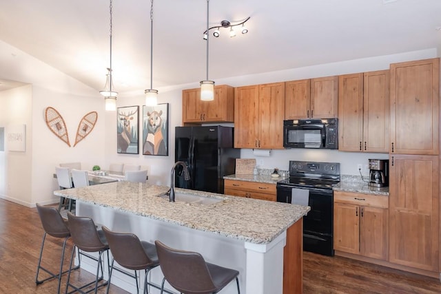 kitchen featuring pendant lighting, a kitchen island with sink, sink, and black appliances