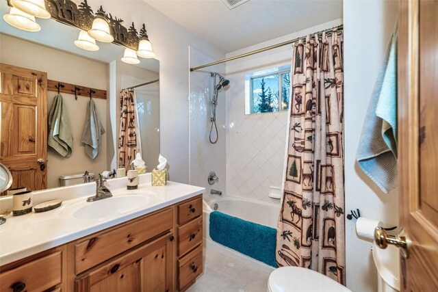 full bathroom with tile patterned floors, shower / tub combo with curtain, vanity, and toilet