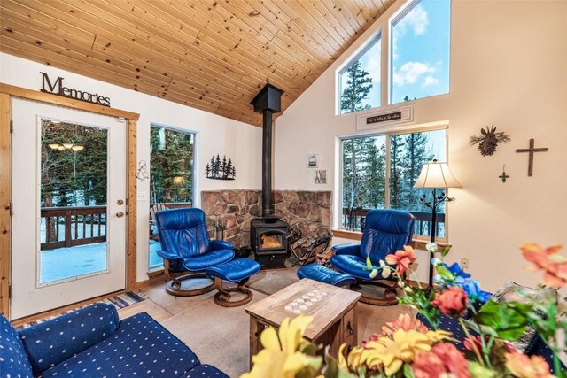 sunroom / solarium featuring lofted ceiling, a wood stove, and wood ceiling