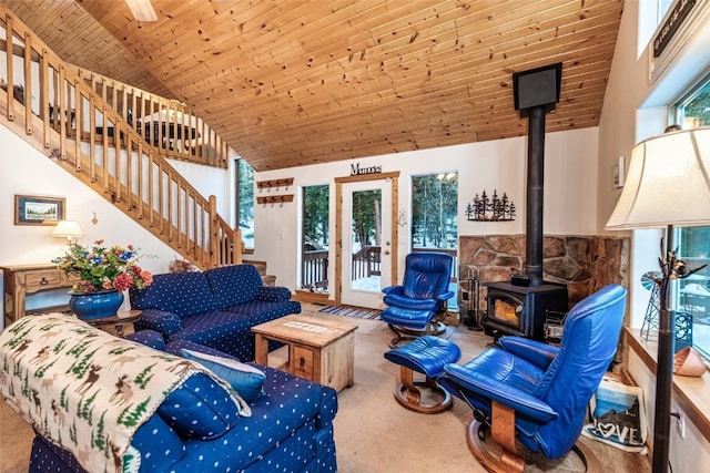 carpeted living room featuring a wood stove, high vaulted ceiling, and wooden ceiling