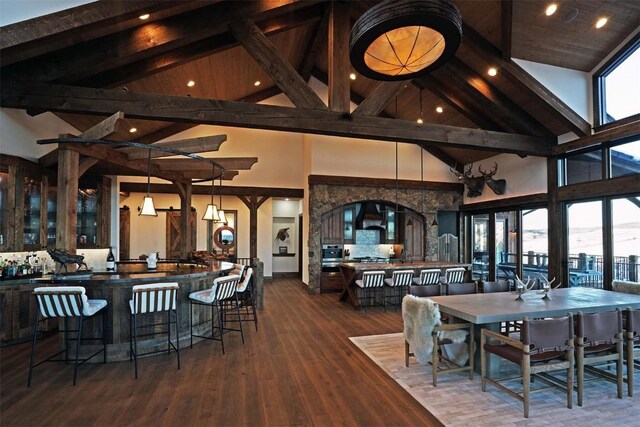 dining space featuring beamed ceiling, high vaulted ceiling, and dark hardwood / wood-style floors