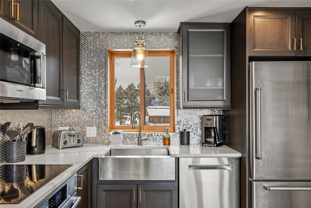 kitchen with sink, decorative backsplash, dark brown cabinets, and appliances with stainless steel finishes