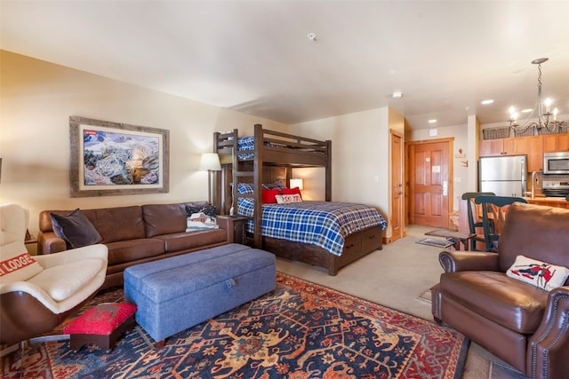 carpeted bedroom with freestanding refrigerator and a notable chandelier