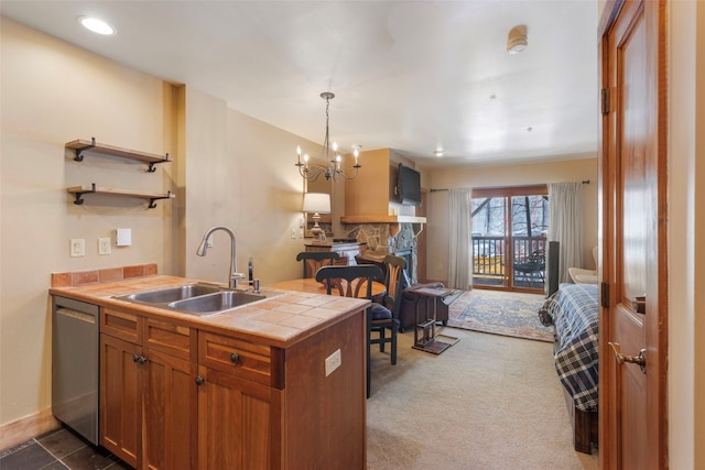 kitchen with brown cabinetry, decorative light fixtures, a sink, and tile countertops