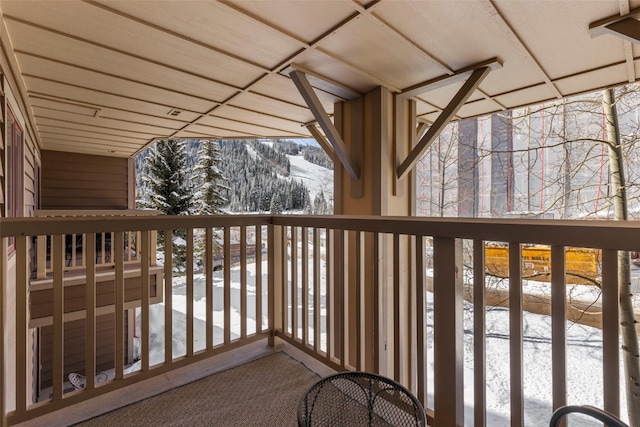 view of snow covered back of property