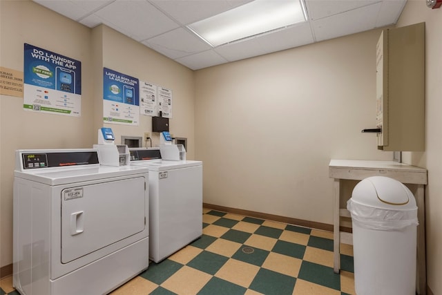 community laundry room featuring washer and dryer, dark floors, and baseboards